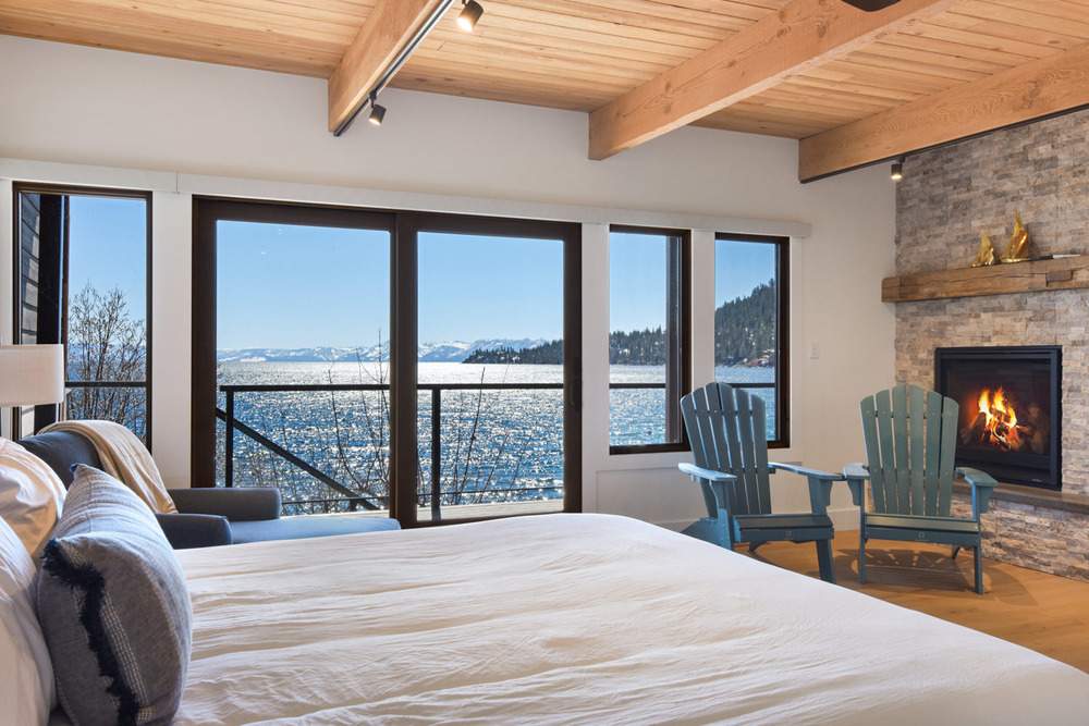 bedroom with fireplace and lake view