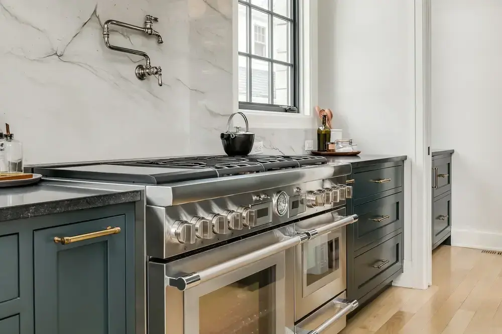 Top-tier kitchen remodel in Incline Village with elegant marble backsplash, stainless steel appliances, and blue cabinetry.