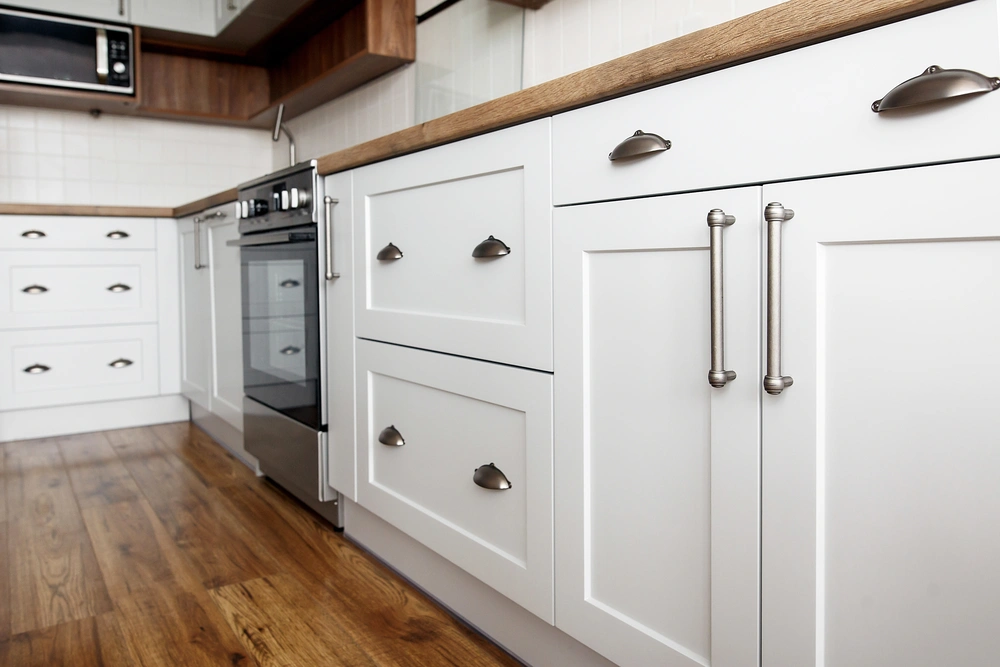 Beautiful custom white cabinetry in a newly remodeled kitchen in Incline Village, showcasing polished hardware and wooden flooring.