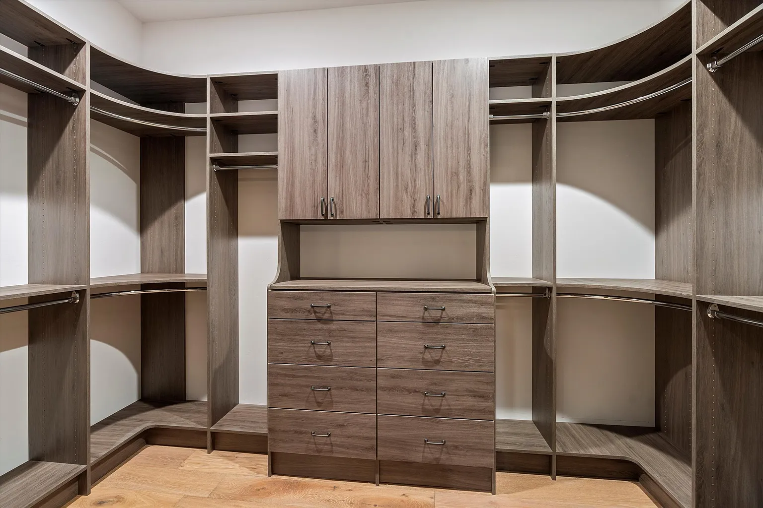 Custom-built walk-in closet with dark wood shelves and drawers, showcasing precision craftsmanship in a Minden home renovation.