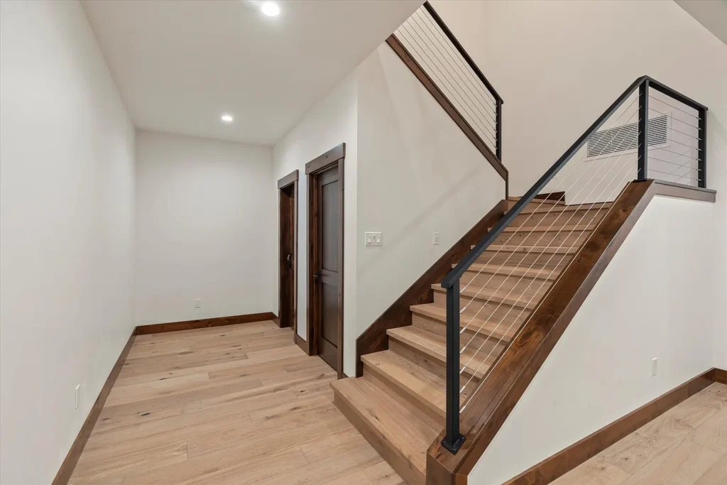 Custom home addition in Carson City with modern staircase, cable railing, and wood trim detailing.